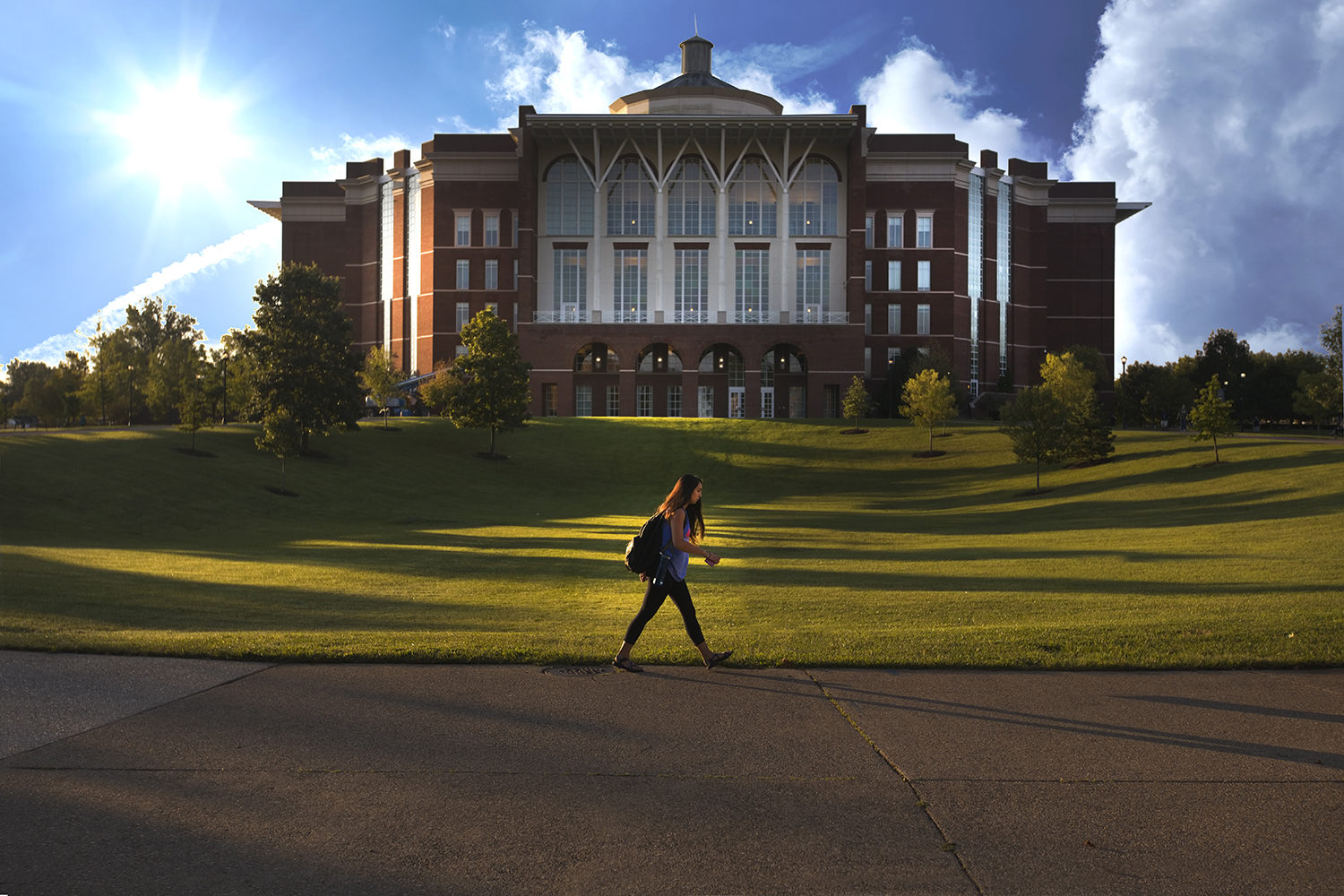 female-student-walking-in-front-of-library