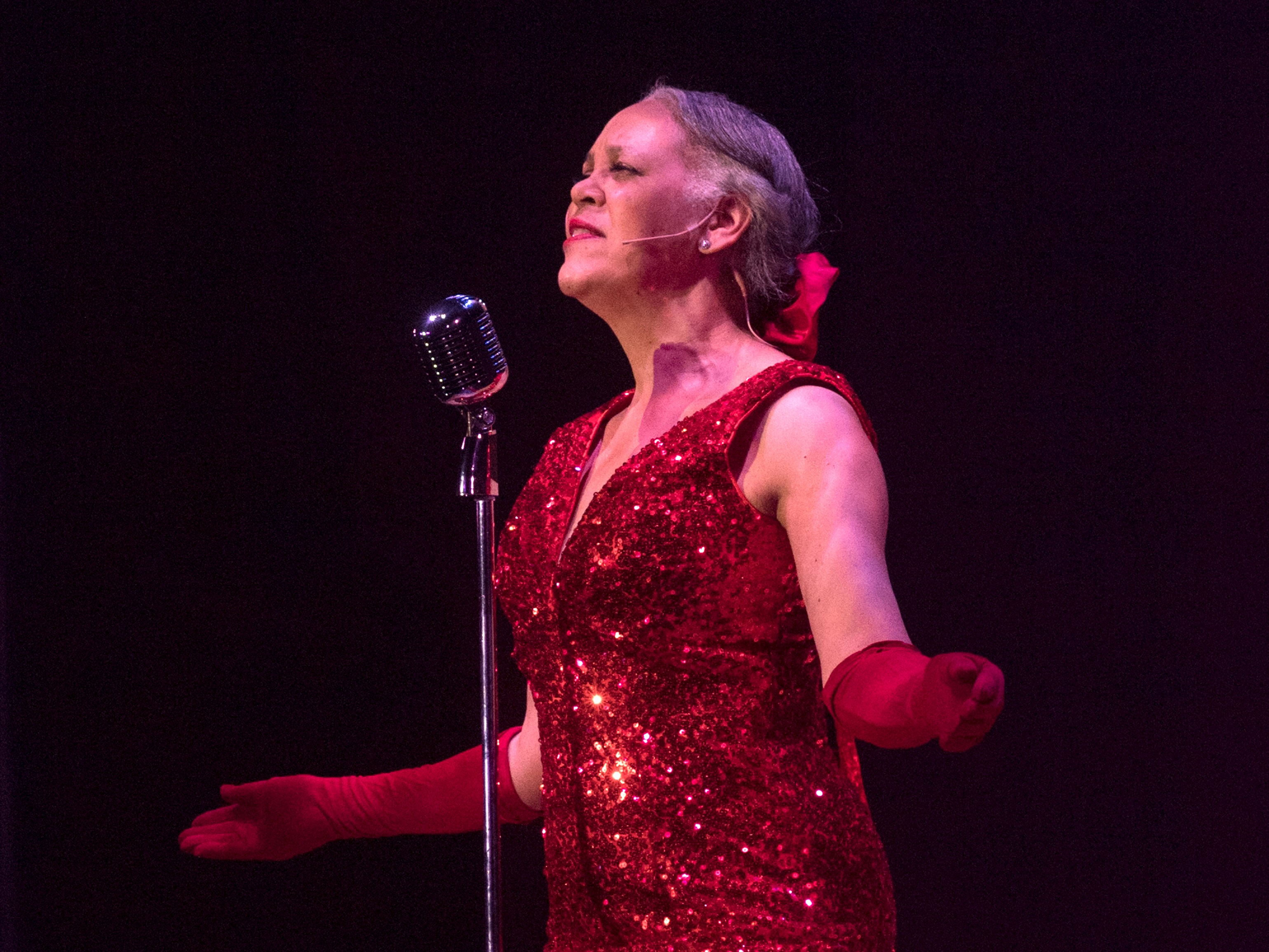 Photo of Alicia McCorvey wearing red sequined dress and opera gloves